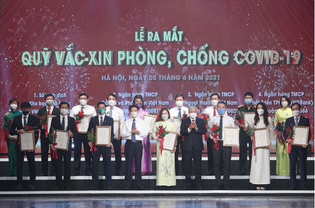 Ông Đỗ Văn Chiến, Bí thư Trung ương Đảng, Chủ tịch UBTƯ MTTQ Việt Nam trao chứng nhận và hoa cảm ơn các đơn vị, cá nhân tại Lễ ra mắt Quỹ vaccine phòng COVID-19 