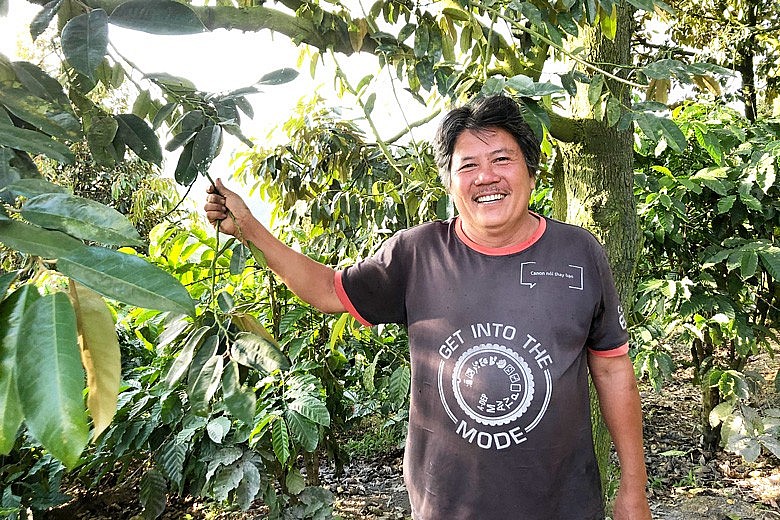 Anh Nguyễn Viết Đỏ bên vườn trồng sầu riêng của gia đình