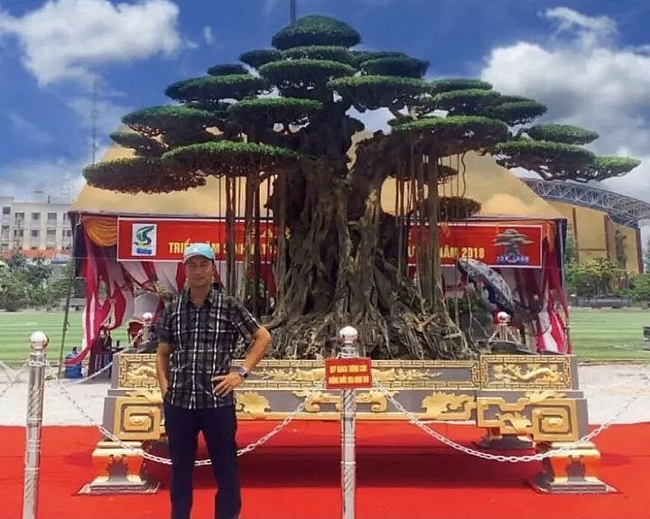 Anh Phan Văn Thái và tác phẩm cây sanh cổ thụ Đại thế vân tùng tại một triểm lãm cây cảnh. (Ảnh nhân vật cung cấp)