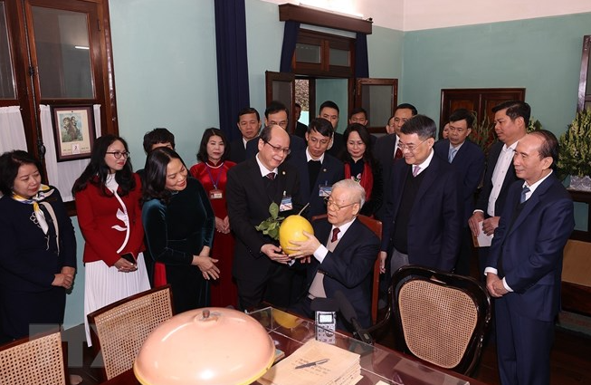 Cán bộ, nhân viên Khu di tích Chủ tịch Hồ Chí Minh kính tặng Tổng Bí thư Nguyễn Phú Trọng trái bưởi trong vườn Bác - Ảnh: TTXVN
