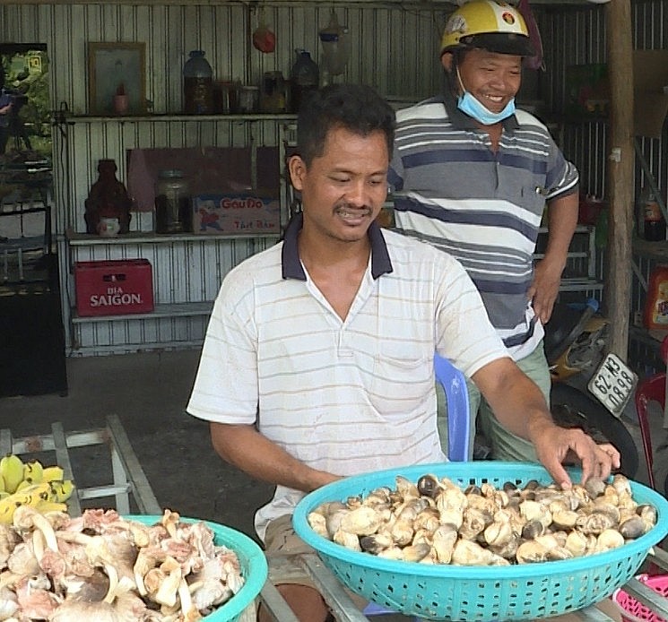 Anh Danh Đầy, tổ trưởng Tổ hợp tác trồng nấm rơm ấp Ngọc Bình đang giới thiệu sản phẩm của HTX