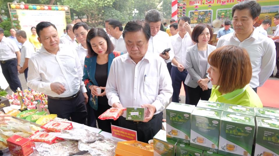 Bộ trưởng Bộ NN&PTNT Lê Minh Hoan và lãnh đạo Thành uỷ - UBND TP Hà Nội thăm gian trưng bày sản phẩm OCOP bên lề hội nghị. Ảnh: Trọng Tùng.