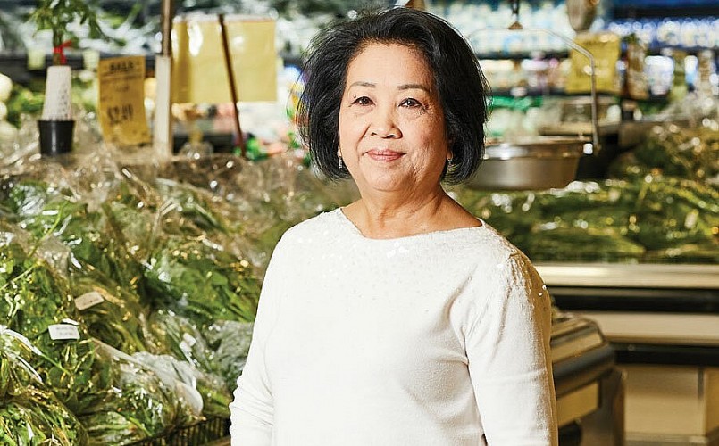 Bà Le Dam Doan đứng cạnh một quầy bán rau muống ở siêu thị tại bang Georgia, Mỹ. Ảnh: Atlanta Magazine