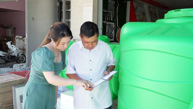 Chị Phan Thu Hiền chủ đại lý vật liệu xây dựng Trần Năm giới thiệu tới khách hàng những ưu điểm của bồn nhựa Plasman. Ảnh: Tân Á Đại Thành.