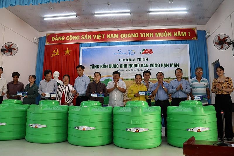 Đại diện lãnh đạo Tập đoàn Tân Á Đại Thành, Báo Nông nghiệp,  Hội Nông dân tỉnh, Huyện uỷ Chợ Lách trao tặng bồn nước cho các hộ nông dân