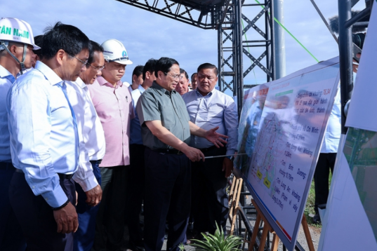 Thủ tướng Phạm Minh Chính nghe đại diện Ban quản lý dự án thuyết minh về tiến độ công trình