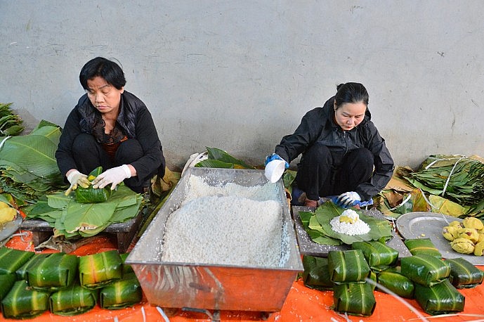 Người dân làng Tranh Khúc đang hối hả gói bánh chưng tết.