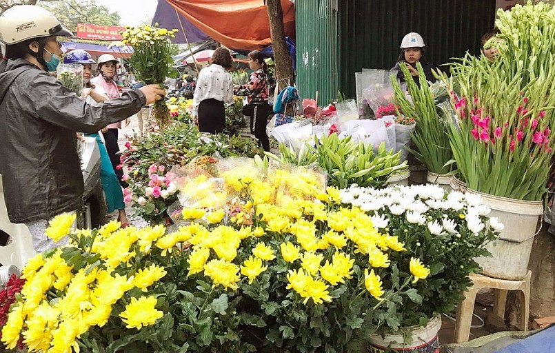 Người tiêu dùng mua hoa tươi tại chợ Kim Liên chuẩn bị cho lễ cúng  rằm tháng Giêng. Ảnh: Hoài Nam