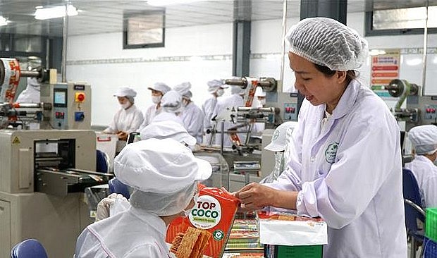 Chị Mai Thị Ý Nhi kiểm tra sản phẩm bánh dừa nướng. Ảnh: Quốc Dũng/TTXVN