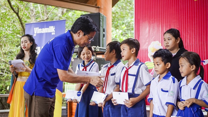 : Ông Lê Hoàng Minh, Giám đốc Điều hành sản xuất Vinamilk, trao học bổng cho học sinh khó khăn tại xã Đất Mũi, tỉnh Cà Mau nhân dịp trung thu