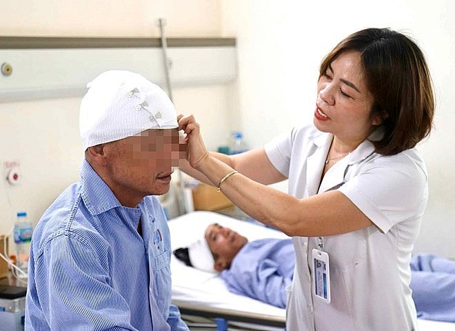 Điều dưỡng Trưởng khoa Ngoại Thần kinh (Bệnh viện K) Nguyễn Thúy Hồng chăm sóc cho người bệnh. Ảnh: Thế Mạnh
