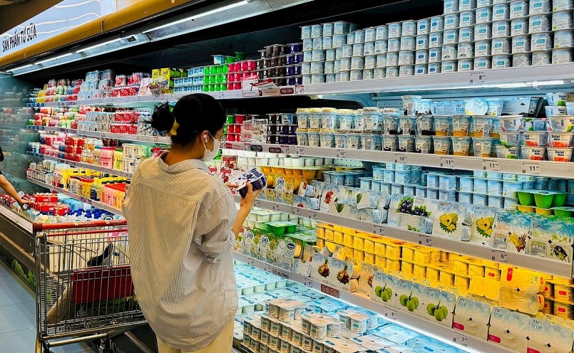 Người tiêu dùng trẻ tại siêu thị hiện đại với lựa chọn đa dạng giữa hàng nội và hàng ngoại – minh chứng cho áp lực cạnh tranh ngày càng lớn trên thị trường nội địa.
