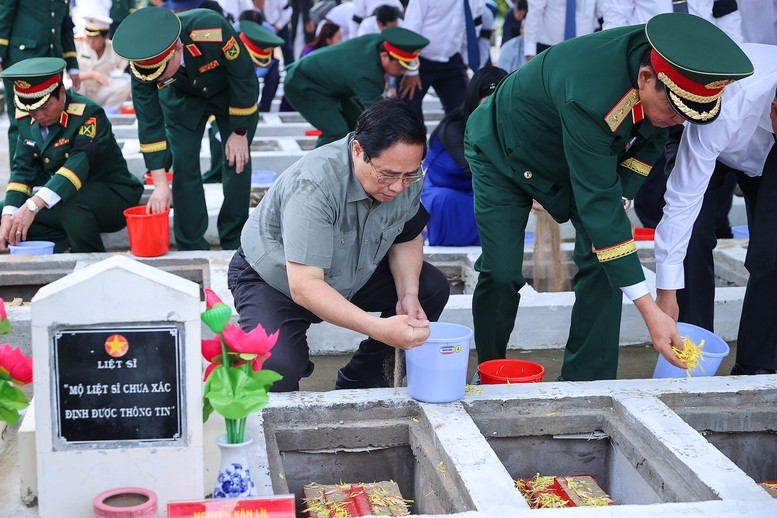 Thủ tướng Phạm Minh Chính cùng đoàn công tác thực hiện nghi lễ an táng hài cốt liệt sĩ tại Nghĩa trang liệt sĩ Dốc Bà Đắc - Ảnh: VGP