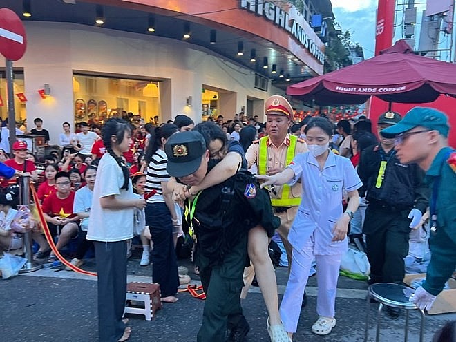Một phụ nữ bất ngờ bị ngất xỉu do tụt huyết áp khi xem diễu binh. Ảnh: Cường Ngô