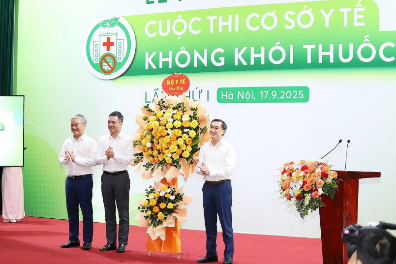 Thứ trưởng Trần Văn Thuấn (bên phải) trao lẵng hoa của Bộ Y tế ﻿chúc mừng Ban Tổ chức cuộc thi.