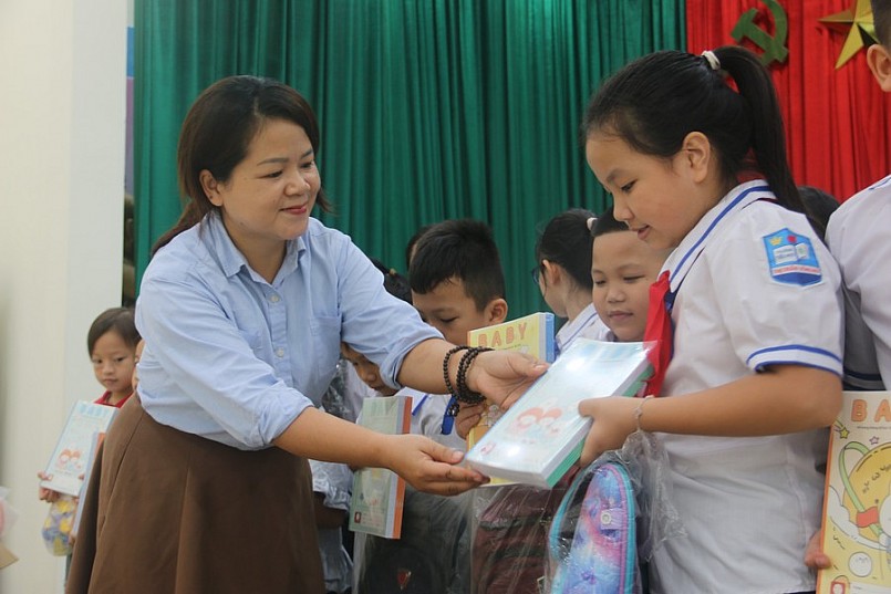 Đại diện Công ty cổ phần dịch vụ và thương mại sách và thiết bị Tây Bắc tặng vở cho học sinh