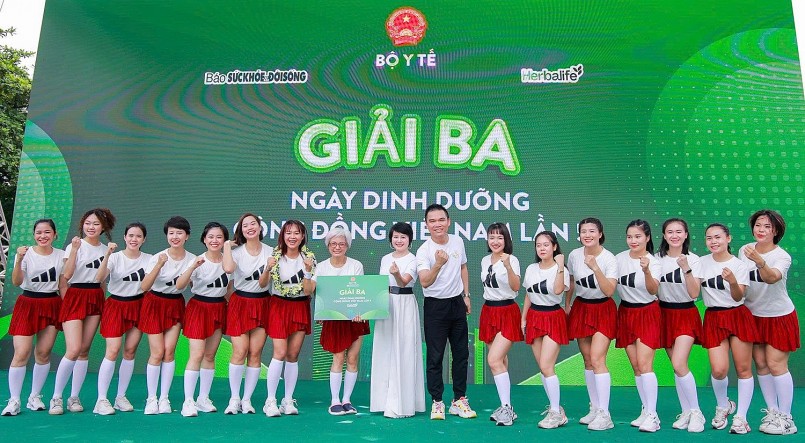 Ông Nguyễn Thành Đạt - Giám đốc Truyền thông cấp cao Herbalife Việt Nam và nhà báo Trần Yến Châu - Phó Tổng Biên tập Báo Sức khỏe và Đời sống, Phó Ban Tổ chức Chương trình tặng hoa cho đội chơi giành giải Ba tại chương trình.