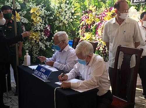 Nguyên Chủ tịch nước Nguyễn Minh Triết (người ngồi bên phải) ghi những dòng tưởng nhớ nguyên Phó Thủ tướng Trương Vĩnh Trọng. Ảnh: VGP/Nguyễn Hoàng