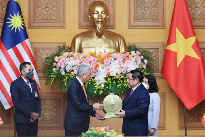 Thủ tướng Phạm Minh Chính trao quà tặng Thủ tướng Ismail Sabri Yaakob. Ảnh: VGP
