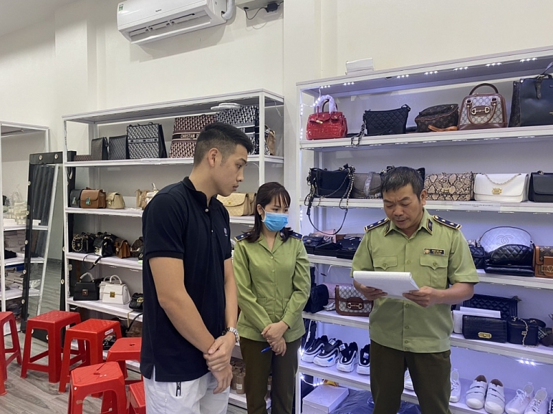 Đoàn kiểm  tra liên ngành Quản lý thị trường, Công an tỉnh đọc quyết định kiểm tra hàng hóa tại cửa hàng số 26 Trần Đăng Ninh (thành phố Nam Định)
