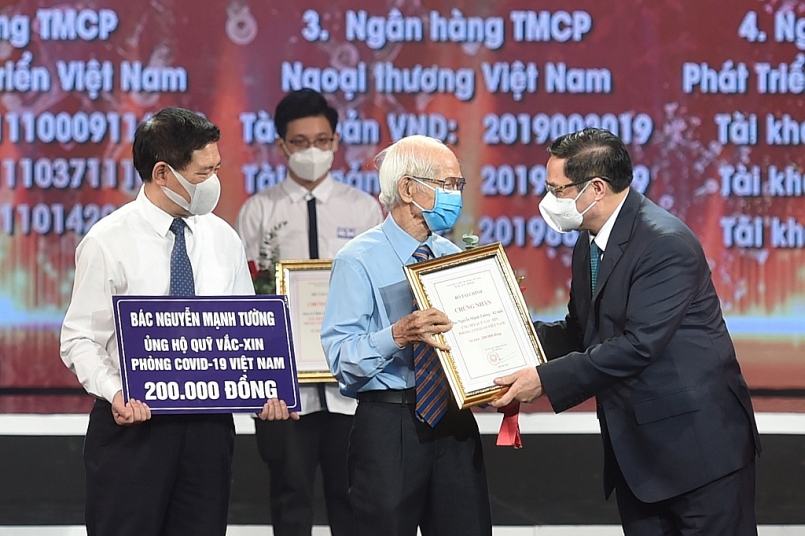 Thủ tướng Chính phủ Phạm Minh Chính trao chứng nhận, hoa cảm ơn bác Nguyễn Mạnh Tường, 82 tuổi, cán bộ hưu trí ngành đường sắt. Ảnh VGP