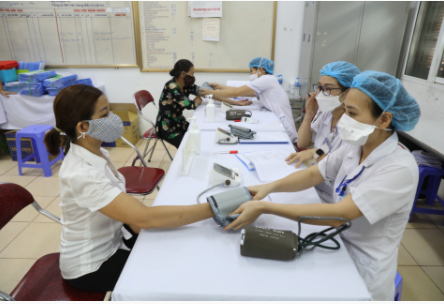 Nhân viên y tế khám sàng lọc cho các tình nguyện viên trước khi tiêm - Ảnh: VGP/Đình Nam