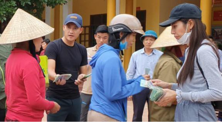 Ca sĩ Thủy Tiên trao tiền hỗ trợ cho người dân bị ảnh hưởng bởi lũ lụt.