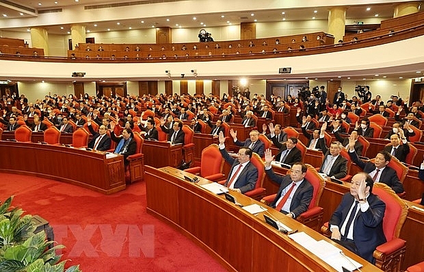 Các đồng chí lãnh đạo Đảng, Nhà nước và các đại biểu biểu quyết thông qua chương trình Hội nghị. (Ảnh: Trí Dũng/TTXVN)