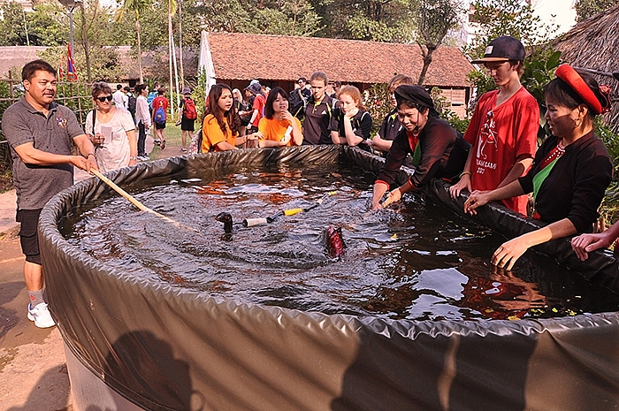 Đông đảo du khách thưởng thức biểu diễn rối nước Đồng Ngư trong không gian khu bảo tồn văn hóa dân gian