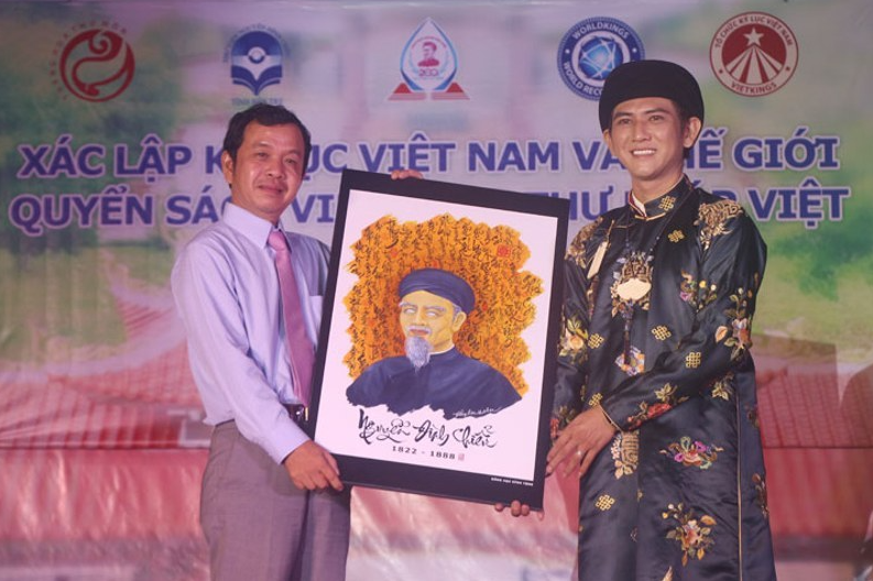 Đại diện Thư viện tỉnh Bến Tre tiếp nhận quyển sách tượng trưng từ Nghệ nhân Vũ Đăng Học. 