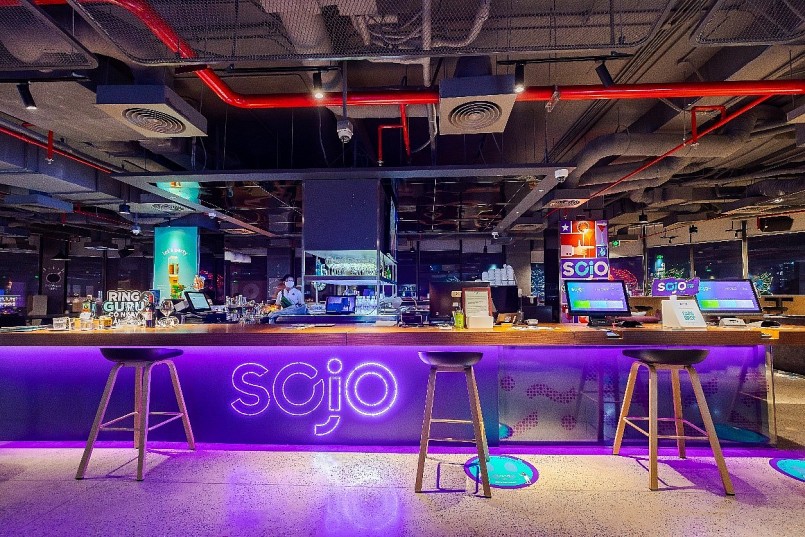 Khu vực check-in kết hợp quầy bar mang phong cách Industrial kết hợp cùng những mảng tím đặc trưng đầy hứng khởi của SOJO.