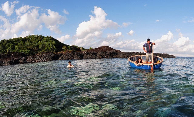 Ngồi trên thuyền thúng, du khách có thể chụp ảnh, ngắm san hô qua làn nước biển trong veo mỗi khi thủy triều rút xuống
