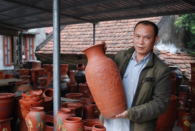 Ông Nguyễn Đức Phú, Chủ nhiệm HTX Hợp gốm Quyết Thành chia sẻ một sản phẩm gốm son tinh xảo từng đạt nhiều giải tại các cuộc thi, triển lãm
